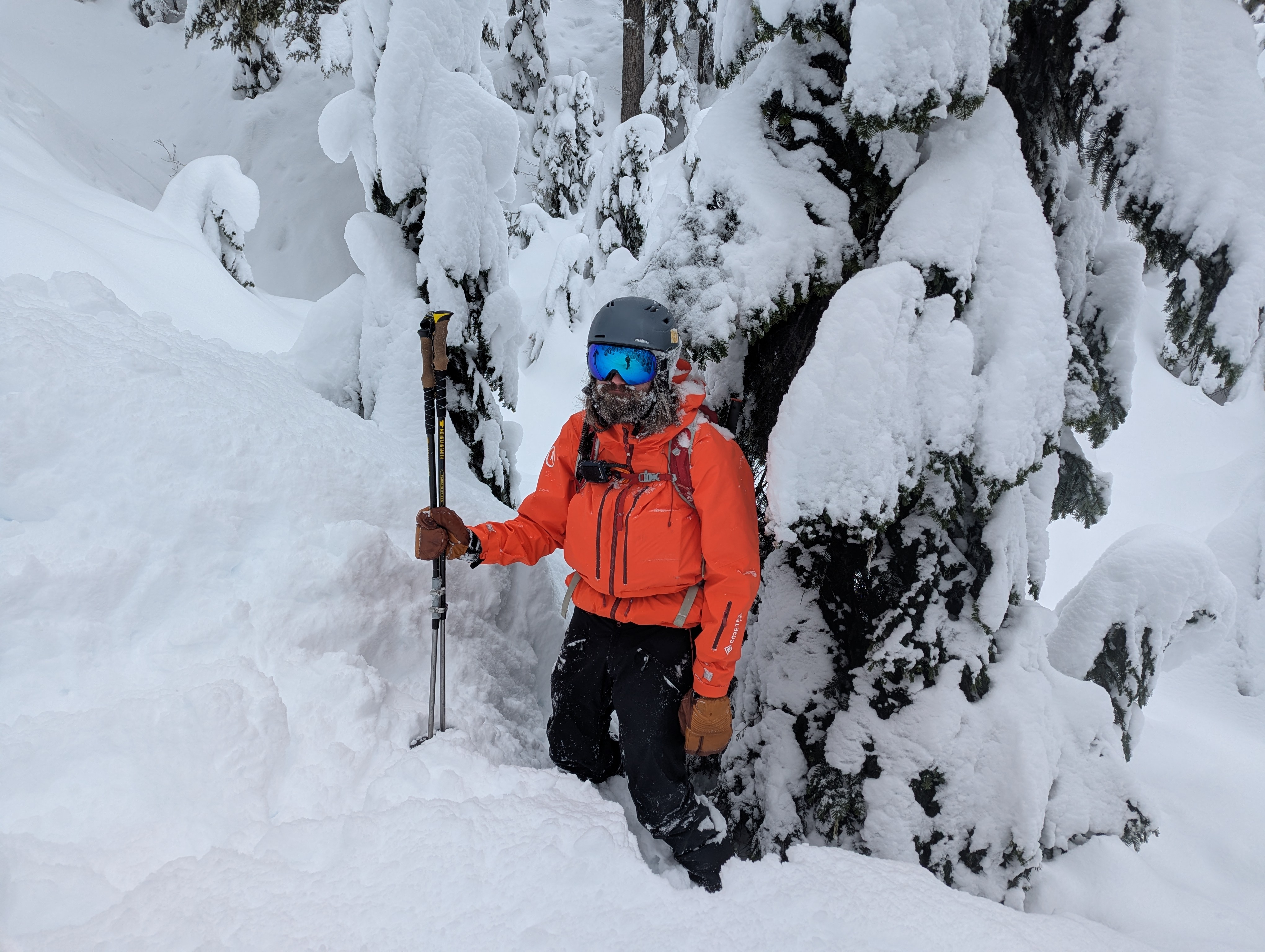 A dejected splitboarder covered in snow