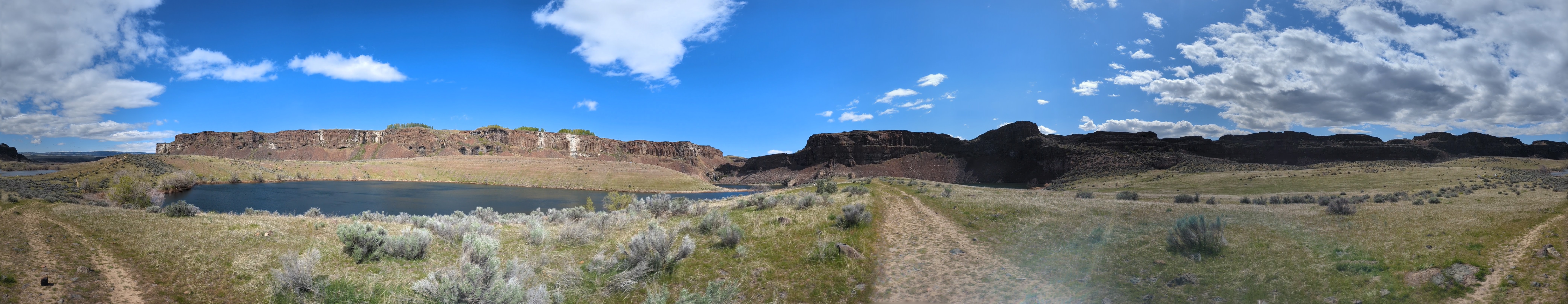A panorama encompassing multiple lakes, the waterfall, and the trail itself