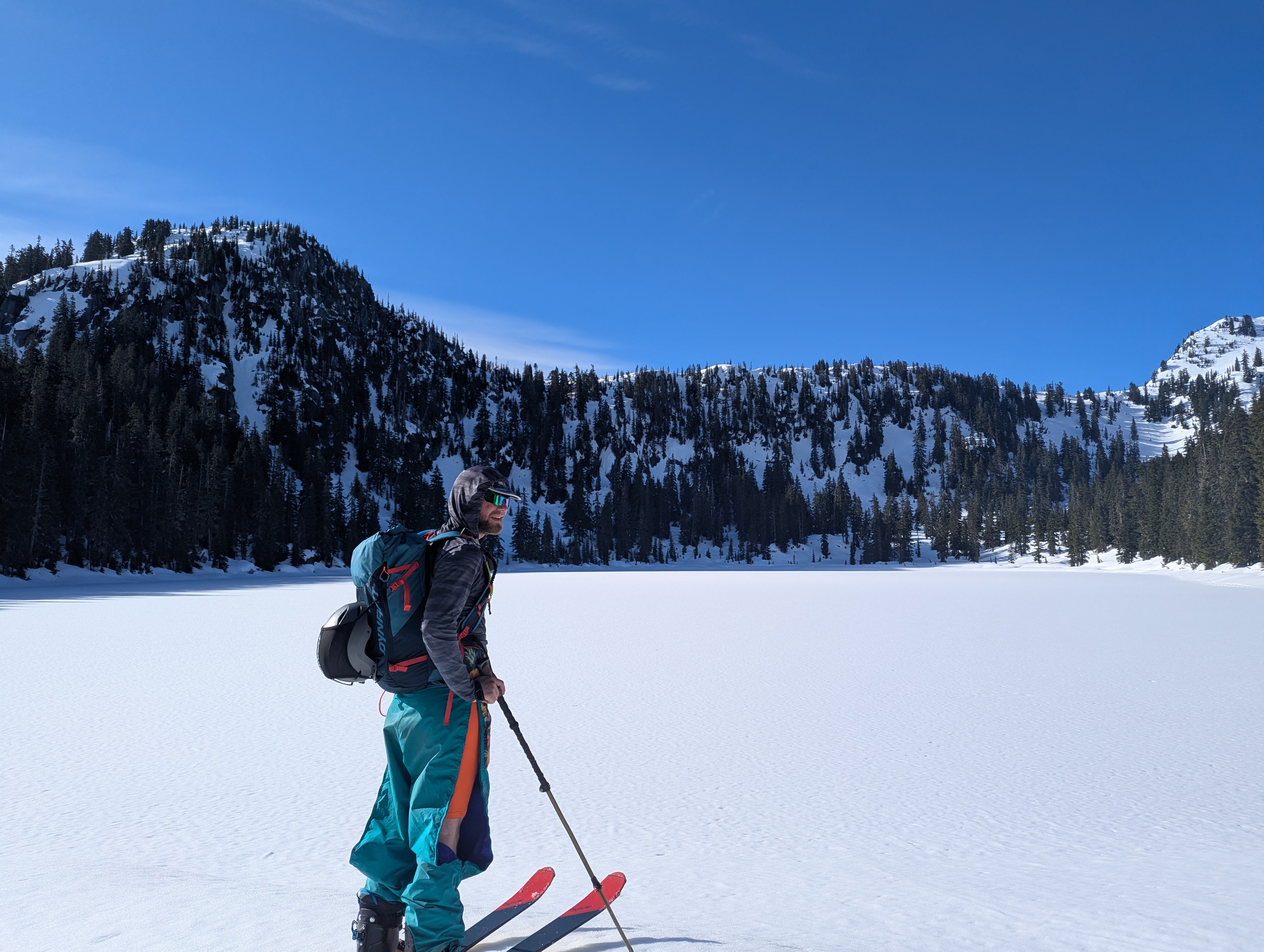 A skier looking out at a snow-covered lake