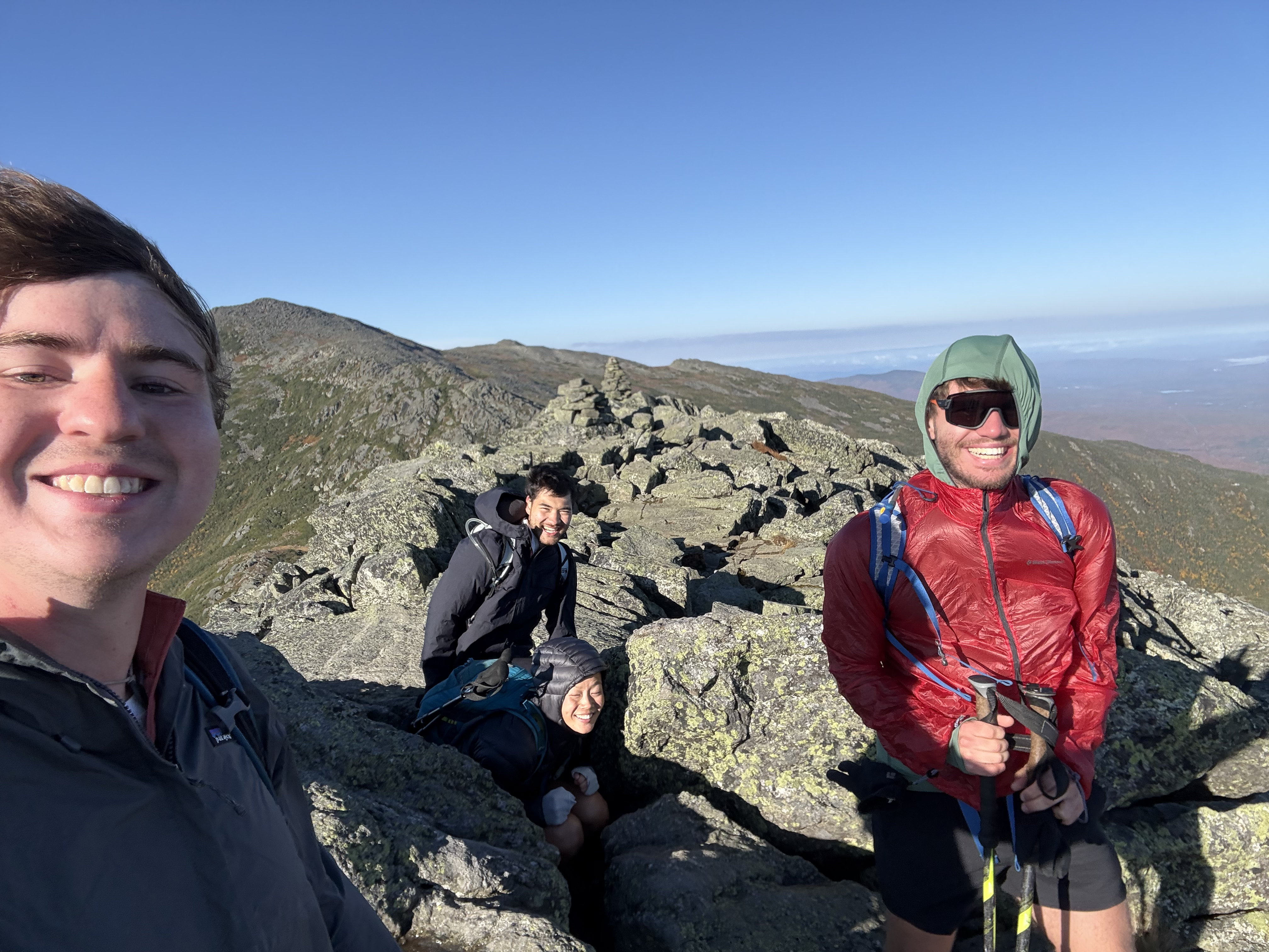 A group selfie with hair and gear fluttering in high winds