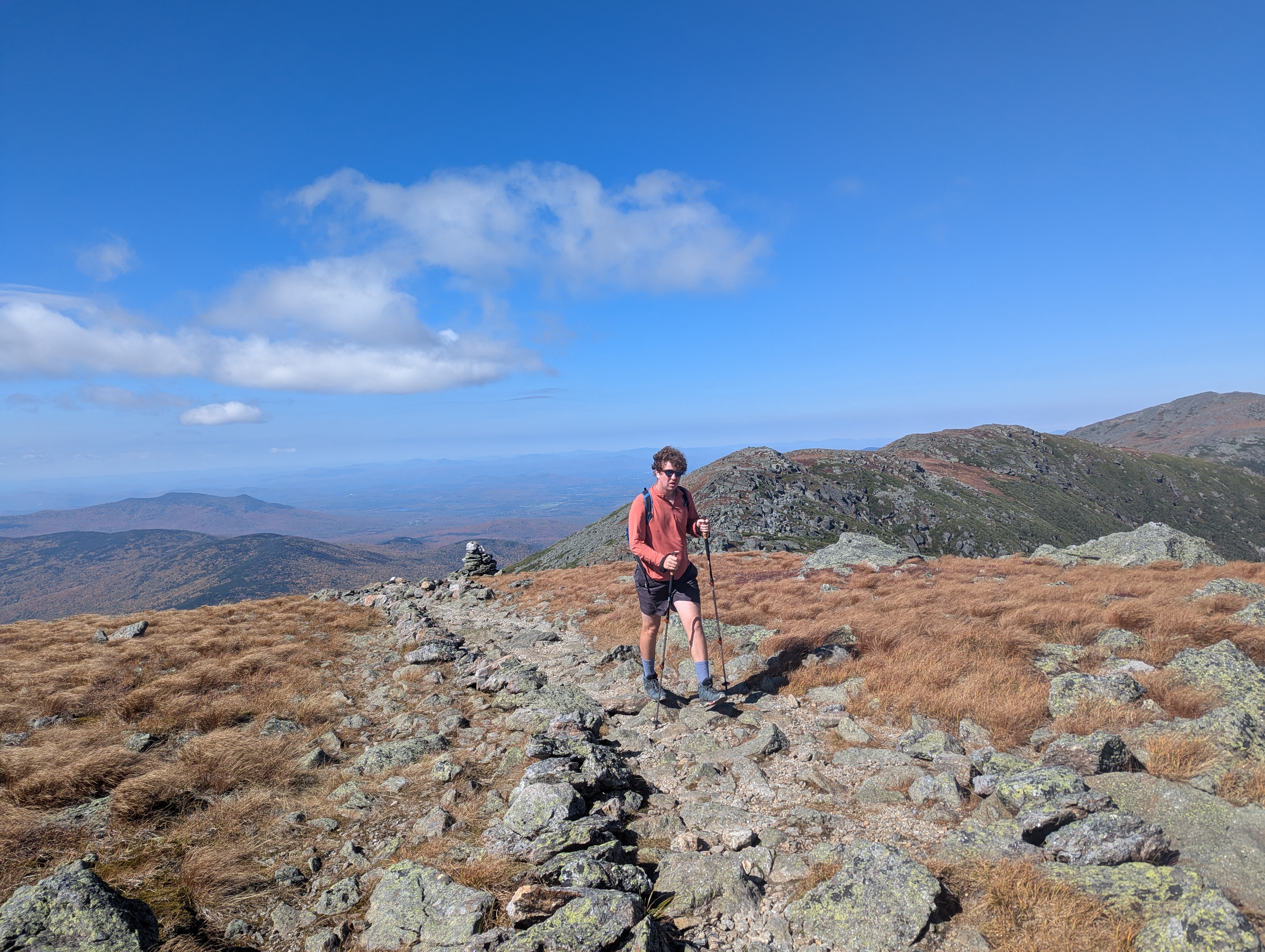 A hiker walking along an alpine ridgeline