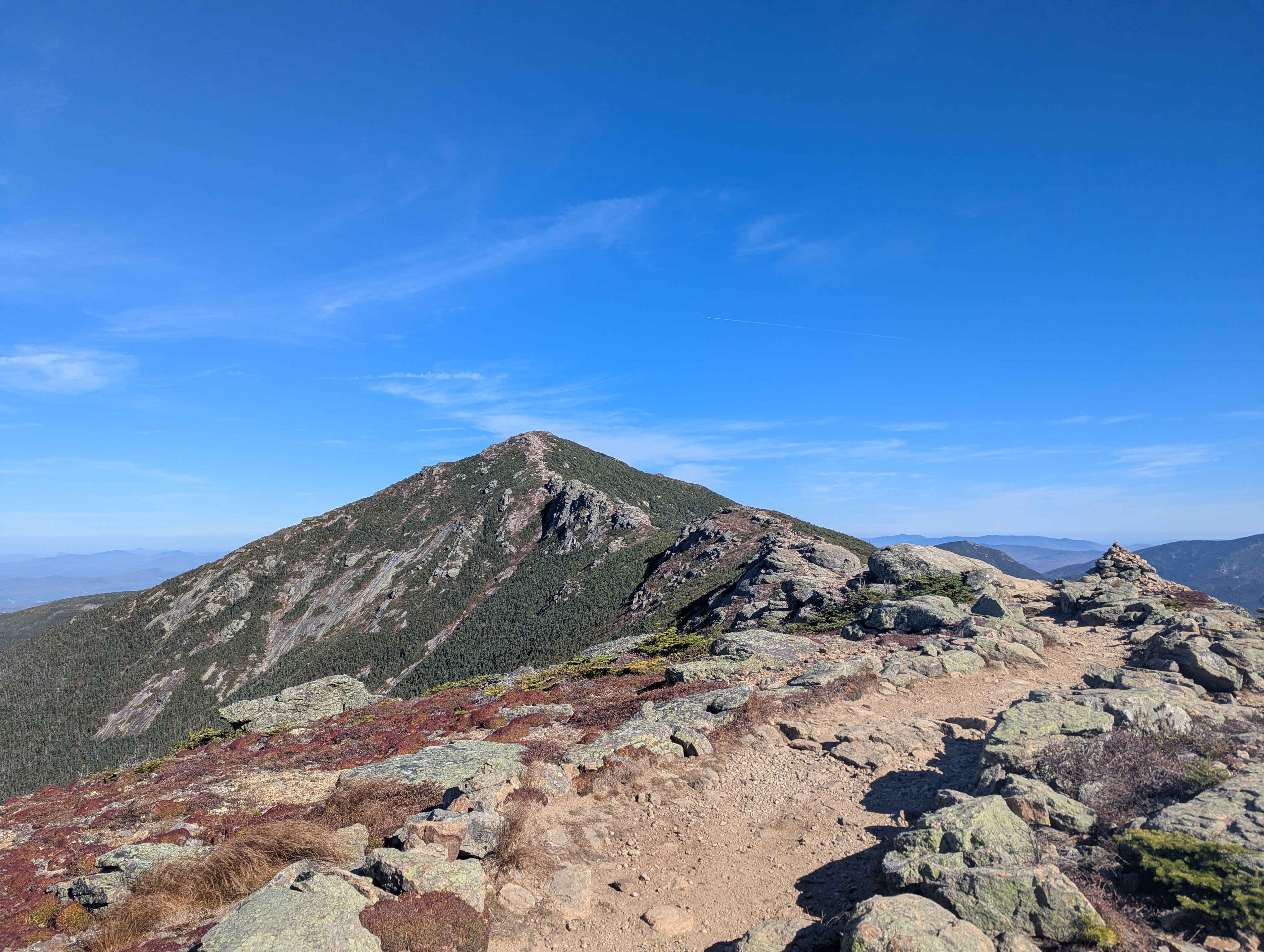A summit in the distance, with the ridgeline trail to it in the foreground