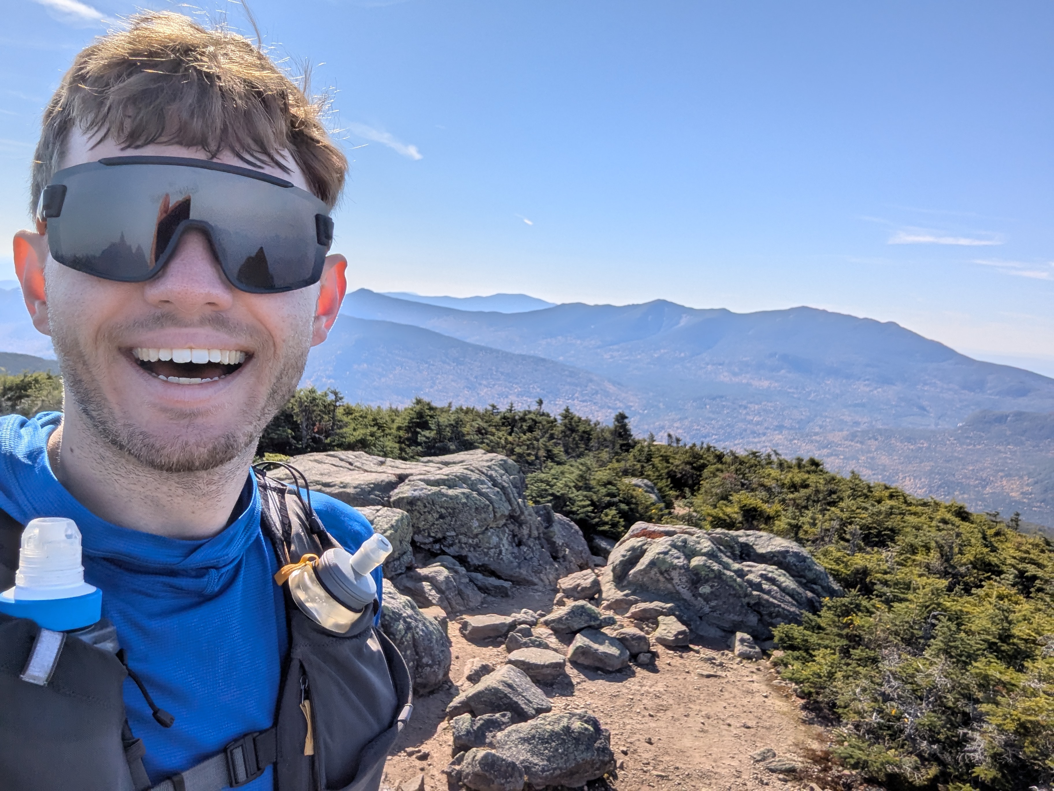 A summit selfie with a ridgeline in the background