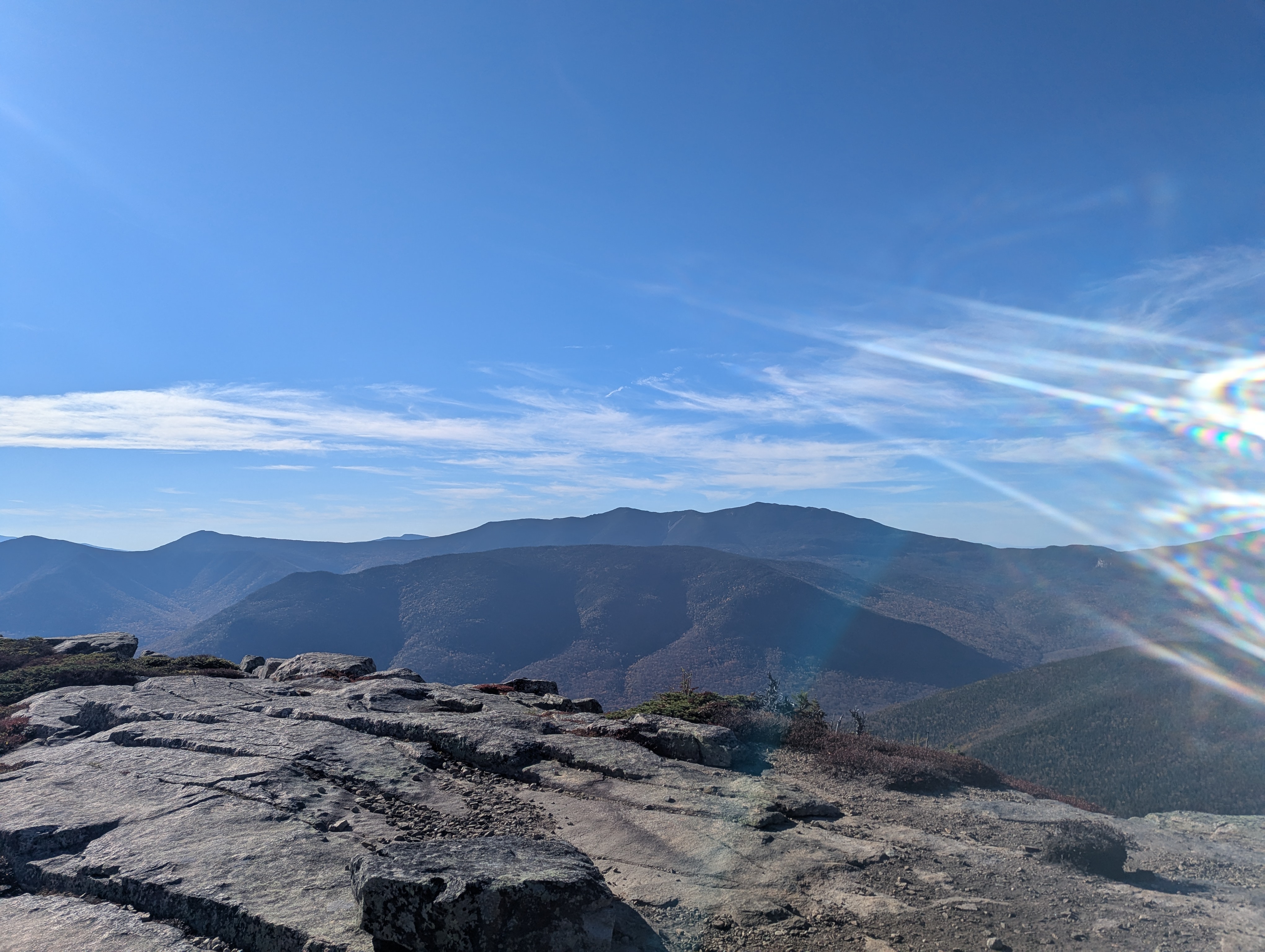 A flatter, more open summit, with a lumpy mountain and then a ridgeline behind it